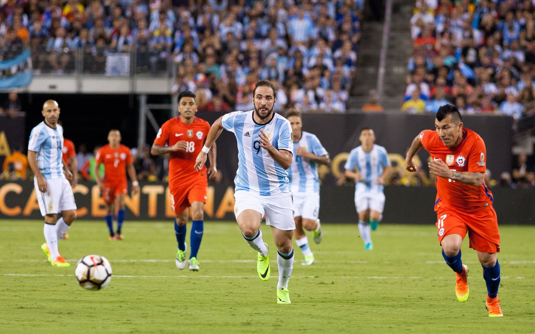 Argentina's Gonzalo Higuain (9) dribbles upfield while other players pursue.